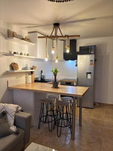 - une cuisine avec une table et quelques tabourets de bar dans l'établissement Apartment indépendant, à Soubès