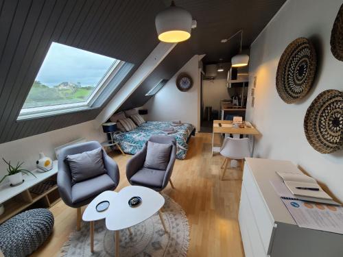 a room with a bed and a table and chairs at Agréable cocon sous les toits - Parking - WiFi in Pléneuf-Val-André