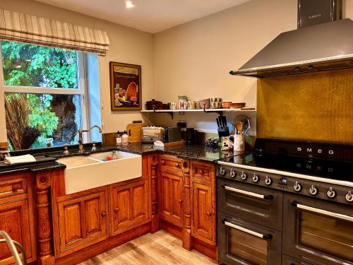 a kitchen with a sink and a stove at Clashmore House Garden Cottage Dornoch in Dornoch