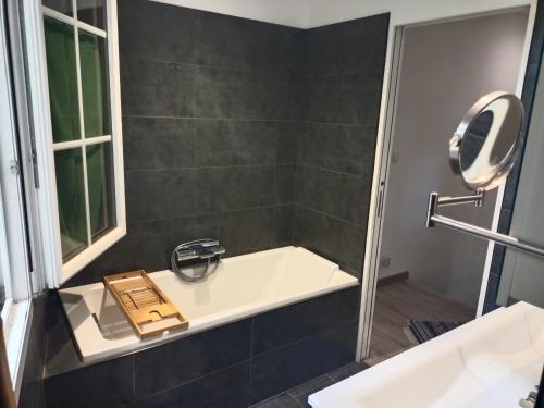 une salle de bain avec une baignoire avec un livre dessus dans l'établissement Maison avec jardin arboré, à Avignon