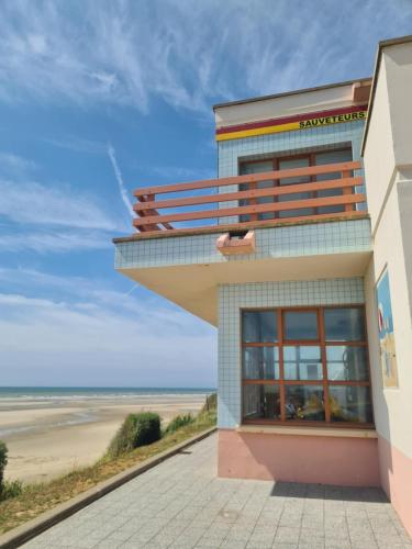a building with a balcony overlooking the beach at Mobil-home Vue mer Piscine - Camping La Falaise Equihen-Plage - La Coquille d'Opale in Équihen-Plage