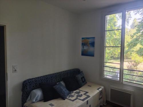 une chambre avec un lit et une fenêtre dans l'établissement Maison avec jardin arboré, à Avignon