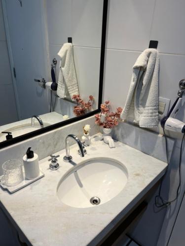 a bathroom counter with a sink and a mirror at Verano Stay Flat Barra Olímpica in Rio de Janeiro