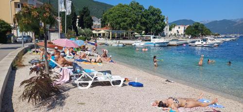 a group of people on a beach near the water at Studio Dream 30m od plaze in Ðenovići