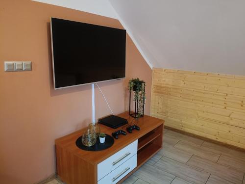 een woonkamer met een flatscreen-tv aan de muur bij Dom Letniskowy in Wielen Zaobrzanski