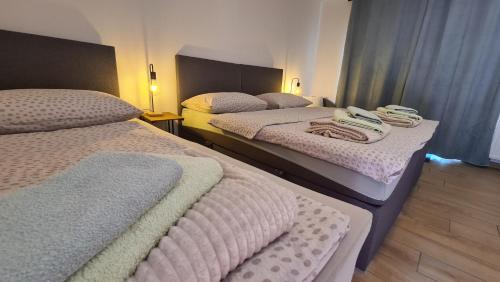 two beds in a hotel room with towels on them at Brne Family House in Postojna