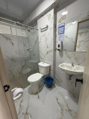 a bathroom with a toilet and a sink at Hotel El Samán in Quinchía
