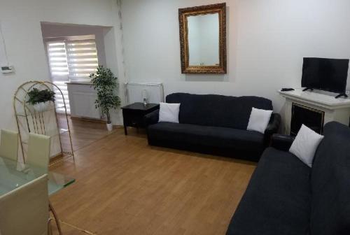 a living room with a black couch and a fireplace at Rooms noclegi in Bytyń