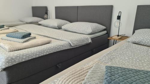 a group of three beds sitting next to each other at Brne Family House in Postojna