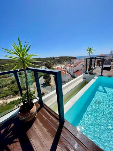 a balcony with a potted plant and a swimming pool at Apartment T3, sea view, swimming pool- Casa do Mar in Zambujeira do Mar