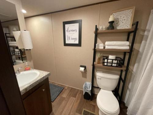 a bathroom with a white toilet and a sink at Willow Retreat in Walterboro
