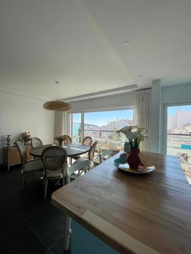 a dining room with a table with a view of the city at Apartment T3, sea view, swimming pool- Casa do Mar in Zambujeira do Mar