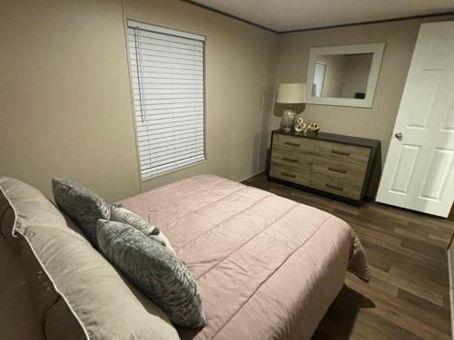 a bedroom with a bed and a dresser with a mirror at Willow Retreat in Walterboro