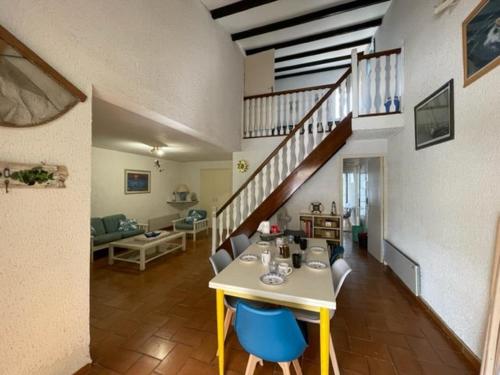 un salon avec une table et des chaises bleues dans l'établissement Maison familiale à 100m de la Plage 8ARGO83, à Saint Pierre La Mer