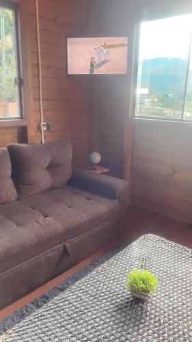 a living room with a couch and a window at Cabana Vale das Pedras in Pedras Grandes