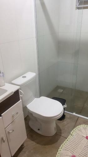 a white bathroom with a toilet and a shower at Cabana Vale das Pedras in Pedras Grandes