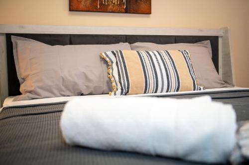 a bed with pillows and a white blanket on it at TONI HOuSE in Alexandroupoli