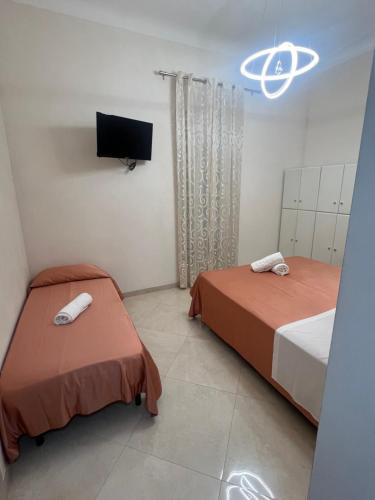 a bedroom with two beds and a flat screen tv at Casa Angelo in Ventimiglia
