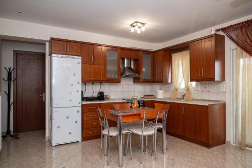 a kitchen with wooden cabinets and a table and chairs at TONI HOuSE in Alexandroupoli