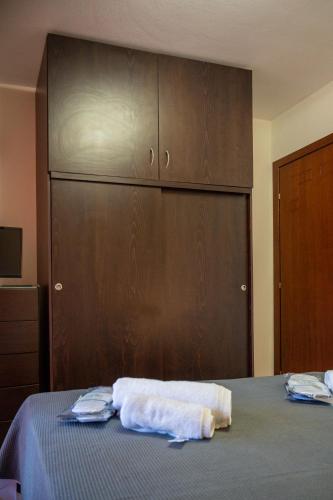 a bedroom with a bed and a wooden cabinet at TONI HOuSE in Alexandroupoli