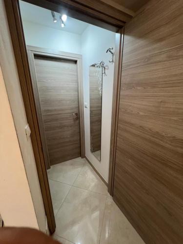 a bathroom with a wooden door with a mirror at Casa Angelo in Ventimiglia