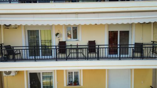 a building with a balcony with chairs on it at TONI HOuSE in Alexandroupoli
