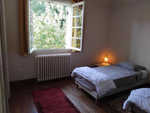 une chambre avec deux lits et une fenêtre dans l'établissement Maison au bord d'un cours d'eau, à Castels