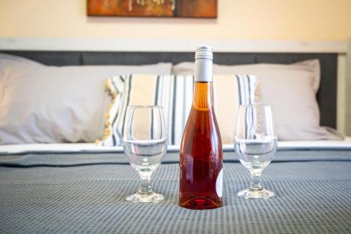 a bottle of wine and two wine glasses on a table at TONI HOuSE in Alexandroupoli