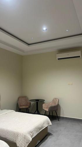a bedroom with a bed and two chairs and a table at استديو جديد in Hail
