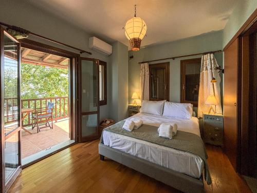 a bedroom with a bed and a balcony at Duchess Eva's Seafront Guesthouse in Chorefto