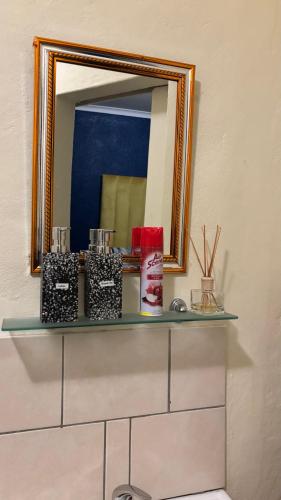 a mirror on top of a shelf in a bathroom at Aneiwa airport lodge in Kempton Park
