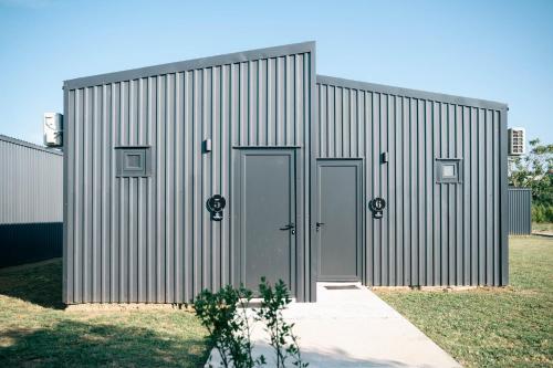 a metal building with two doors on the side at Tommys Village in Ulcinj