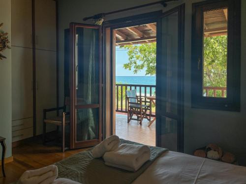 a bedroom with a bed and a view of the ocean at Duchess Eva's Seafront Guesthouse in Chorefto
