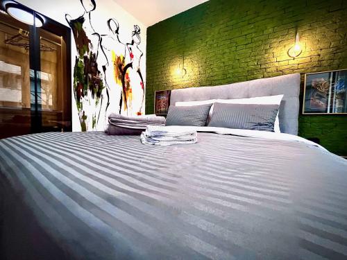a large white bed in a room with a brick wall at Macedonia Square Suite 22 - Pedestrian Street in Skopje