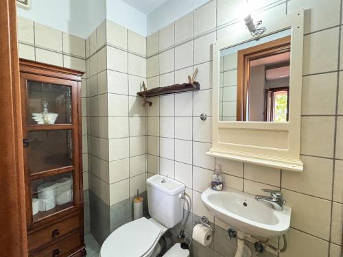 a bathroom with a toilet and a sink at Duchess Eva's Seafront Guesthouse in Chorefto