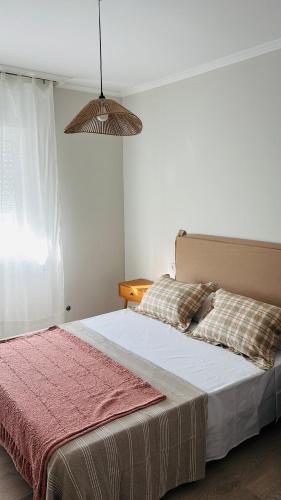 a bedroom with a large bed with a red blanket at Apartamento Mar de Cruz in Pontevedra