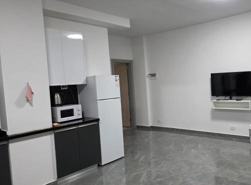 a white kitchen with a refrigerator and a microwave at Chouf View Residence in Baddah