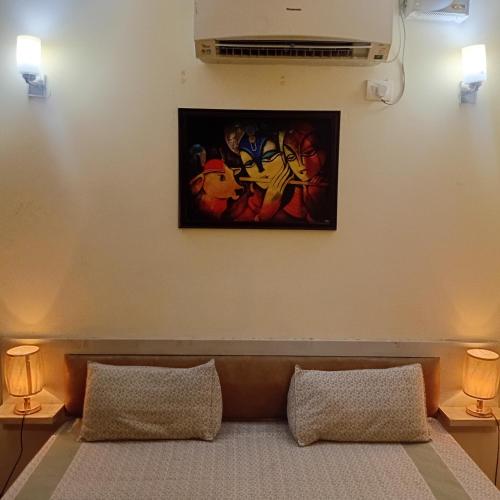 ein Gemälde an einer Wand über einem Sofa mit zwei Lampen in der Unterkunft Organic Stay in Greater Noida