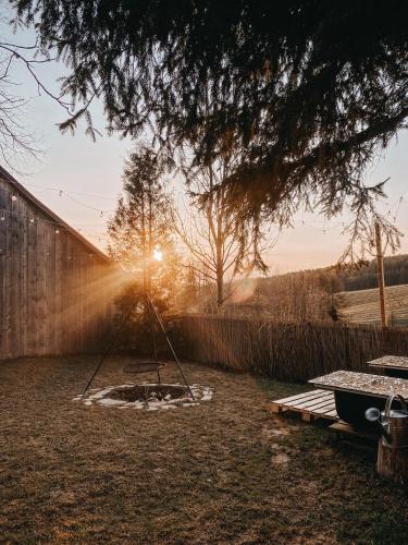a fire pit in a yard with the sun setting at Okno w Gorce-magiczny apartament na uboczu nad jeziorem Czorsztyńskim, Velo Czorsztyn, Szczawnica, Zakopane in Maniowy