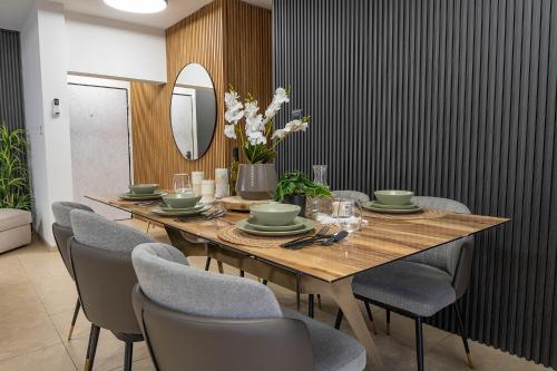 a dining room with a table with chairs and a mirror at וילה פלואלס בוטיק in Shahar