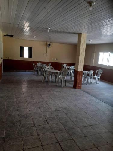 a room with tables and chairs in a building at CHÁCARA PARA ROMEIROS- próximo ao santuário de nossa senhora in Roseira