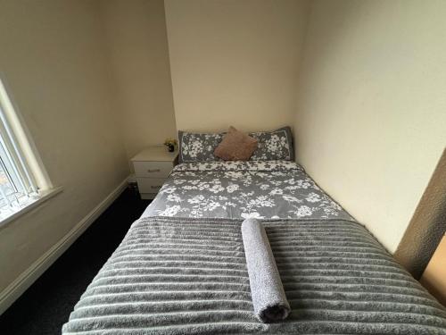a small bedroom with a bed with a blanket at Simple Lodge in Wakefield