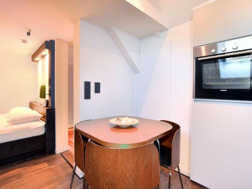 ロベールヴィルにあるModern and cozy studio in a former coach houseの小さなテーブルとベッドが備わる小さな客室です。