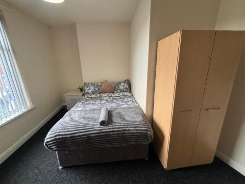 a small bedroom with a bed and a dresser at Simple Lodge in Wakefield