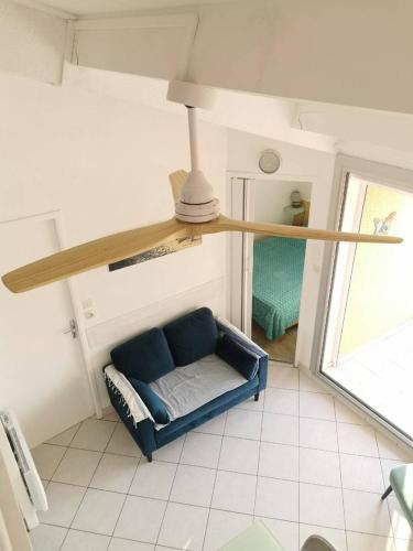 - un salon avec un canapé bleu et une étagère dans l'établissement Appartement T2 Cabine, mezzanine Saint Pierre la mer 4oliv41, à Saint Pierre La Mer