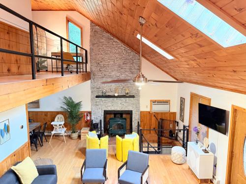 un soggiorno con camino e soffitto in legno di Bethel Escape Hot Tub 4 beds Game Room and Fire pit Fully Stocked Kitchen a Smallwood