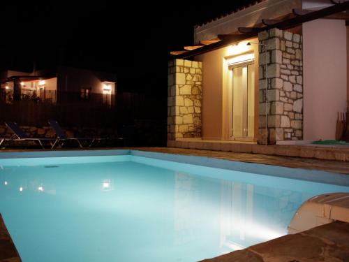 a swimming pool at night in front of a house at Pretty Holiday Home in Grays in Loutra