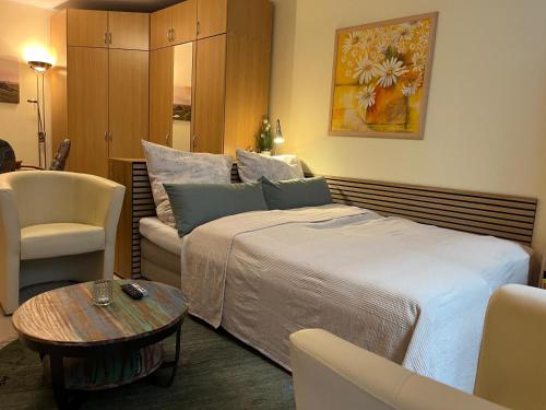 a hotel room with a bed and a chair and a table at Lovely Souterrain Apartment in Solingen