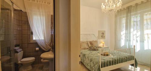 a bathroom with a bed and a toilet and a chandelier at Giardino D'amore By Belcanto Villas in Piano di Mommio