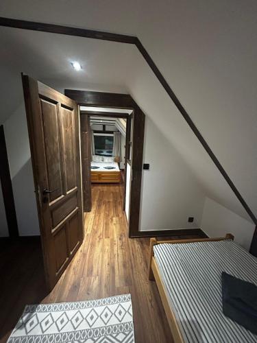 a room with a staircase with a bed and a mirror at Domek przy Rozpadlisku 2 in Podgórzyn